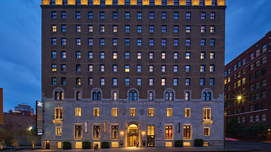 Image of a large hotel building at night with lights lighting up the facade